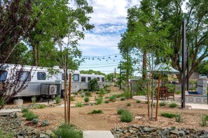 A campground with RVs, trees, and a patio area.