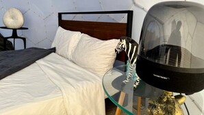 Et moderne soveværelse med et glastilbud, en zebra skulptur og et unikt geometrisk vægdesign.