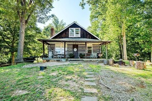 Eine Blockhütte mit Veranda, umgeben von Bäumen.