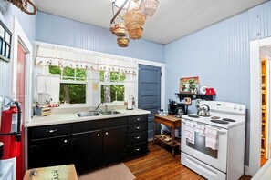 Una cocina pequeña con un lavamanos, estufa y armarios de madera.