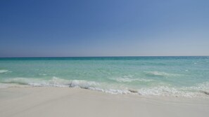 Ein Strand mit klarem türkisblauem Wasser und weißem Sand.