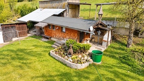A rustic house with a stone foundation, a wooden exterior, and a metal roof.