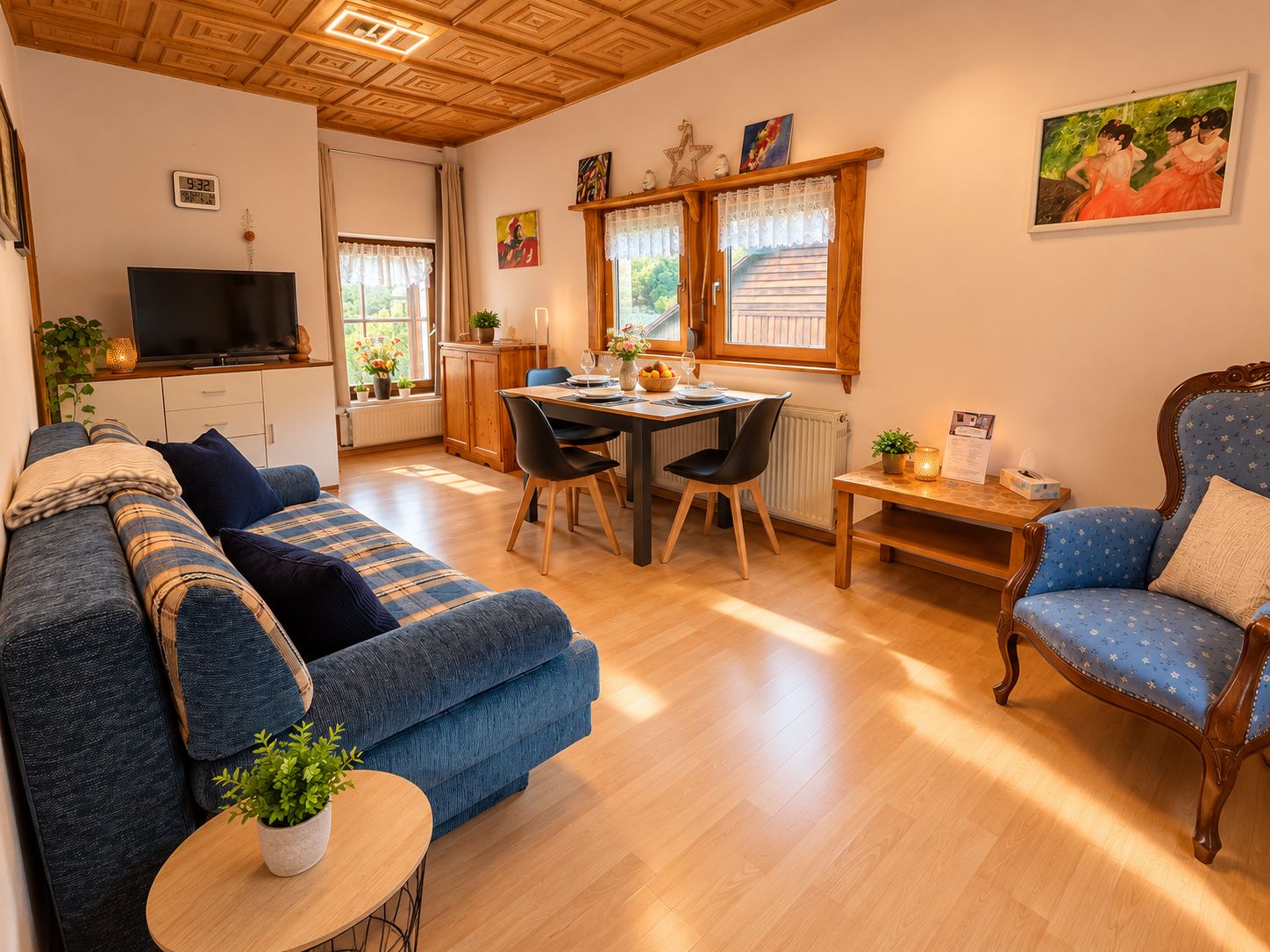 A cozy living room with a sofa, a dining table with chairs, a TV, and a painting on the wall.