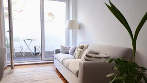 Una sala de estar moderna con un sofá, una lámpara y una planta en maceta.