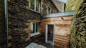 A stone building with a wooden door and a window. - Loft d'Houffalize - by Mansio (Houffalize)