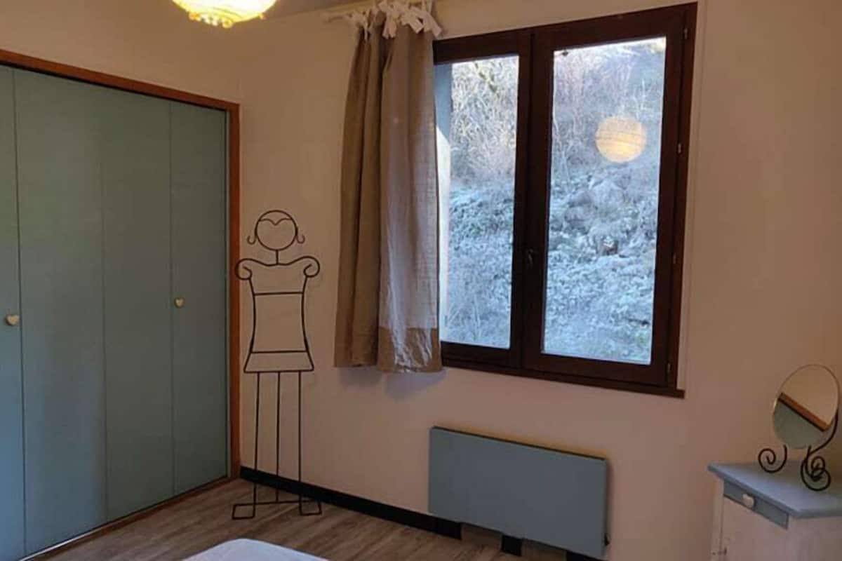 Una habitación con un armario grande, un radiador y una ventana con vistas a un paisaje nevado.