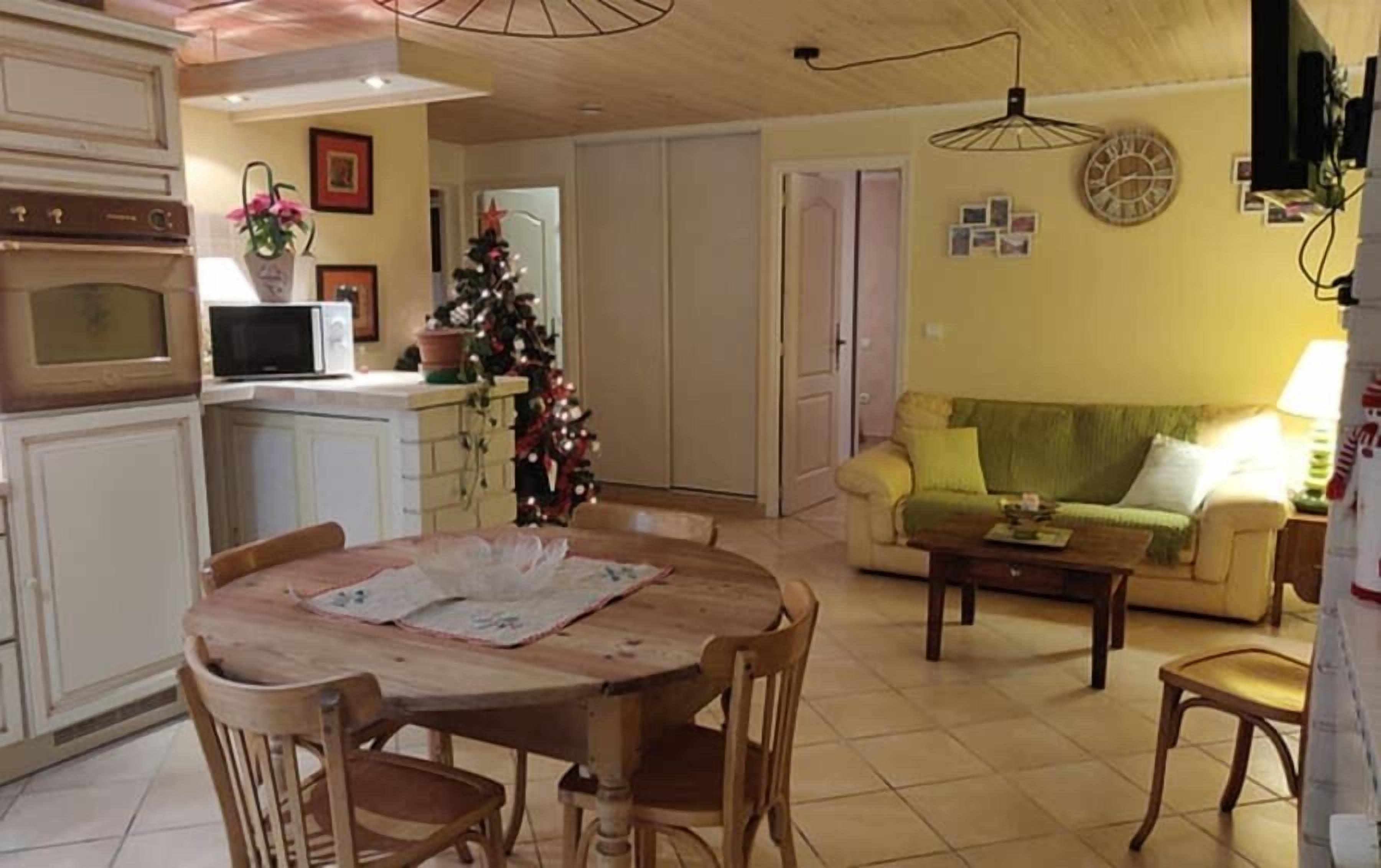 Un salon confortable avec une table à manger, des chaises, un canapé et un coin cuisine équipé d’appareils électroménagers.