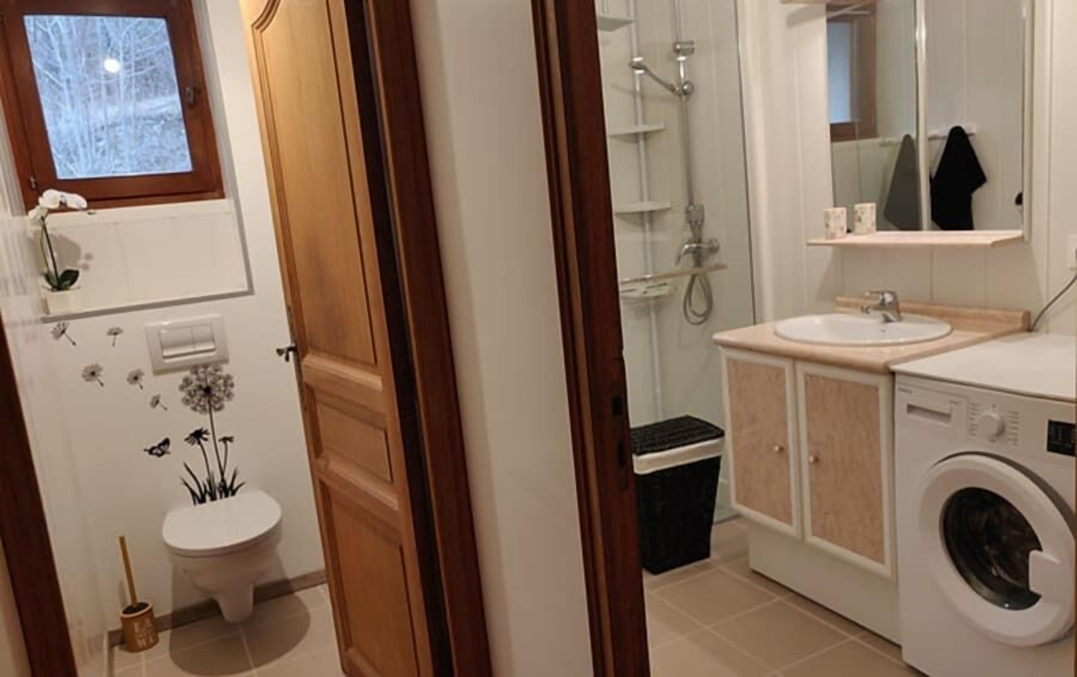 Une salle de bain équipée de toilettes, d’une douche, d’un lavabo et d’un lave-linge.