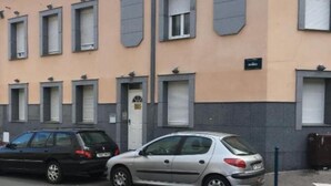 Egy sorban egymás mellett álló, kétemeletes társasház, egységes homlokzattal, központi bejárati ajtóval, mely felett egy kis ablak található, és a jobb oldalon jól látható tábla van.