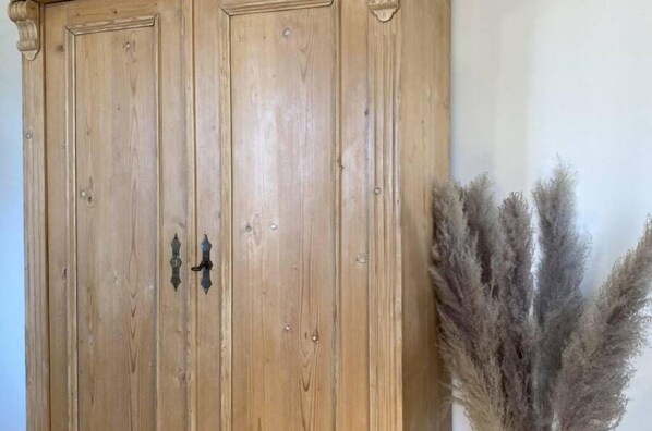 A wooden wardrobe with two doors and a handle. - Domaine Font Castel (Béziers)