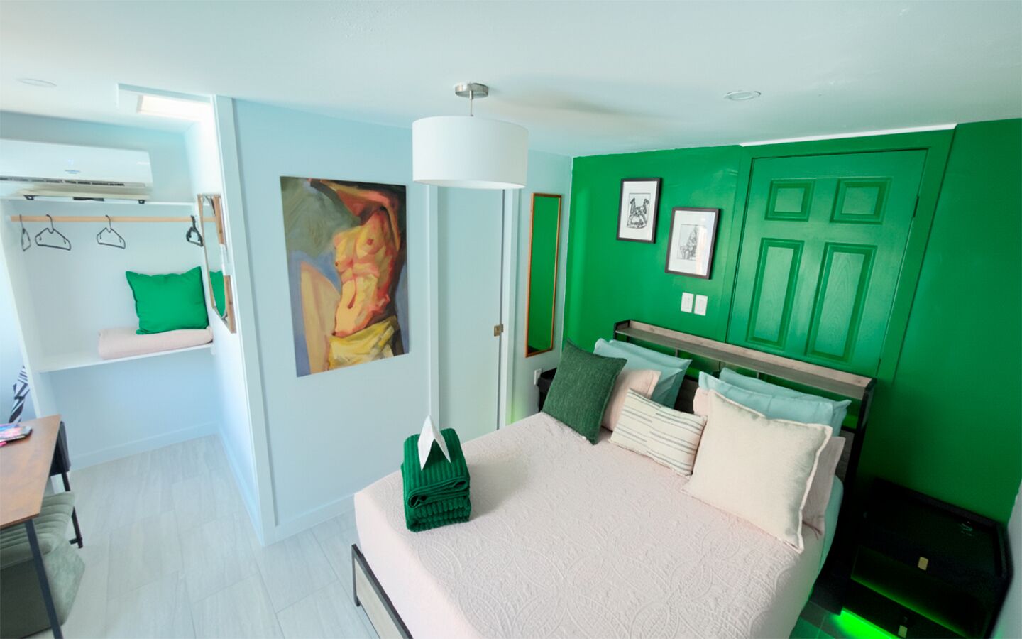Bright and inviting bedroom in The Green Room, featuring a queen bed, fresh green accents, and a clean, modern design.