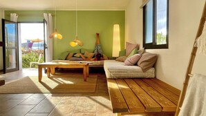 Ein gemütliches Wohnzimmer mit einer Couch, einem Couchtisch und einer Hängelampe.