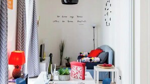 A modern living room with a dining table, chairs, a sofa, and a decorative wall with a clock. - Sixty one luxury room Apartment 100 sqm.,central, in prestigious area. (Roma)