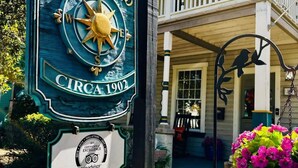 Ein Schild für 'At Journeys End' mit einem Kompass, einem TripAdvisor-Zertifikat und einem Schild mit der Aufschrift 'Joseph Ellen Vacation Bungalows'.