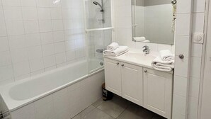 Ein Badezimmer mit Badewanne, Waschbecken und Spiegel.