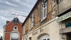 Eine enge Kopfsteinpflasterstraße, rechts befindet sich ein Restaurant namens „Restaurant Bar“. Über dem Eingang ist ein Schild mit der Nummer „03 23 55“ angebracht.