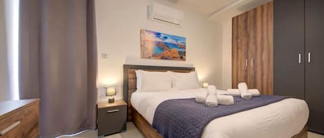A modern bedroom with a large bed, a nightstand, a wooden wardrobe, and a painting on the wall.