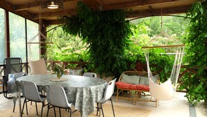 An outdoor patio with a round table, chairs, a hanging chair, and a hammock. - Métairie de Lamourade (Saint-Ferriol)
