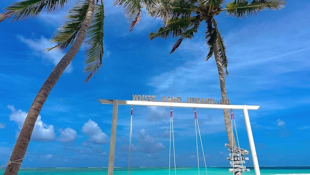 A beach with a swing set labeled "WHITE SAND HIMAND" and palm trees. - WhiteSand (Himandhoo)