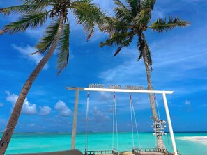 A beach with a swing set labeled "WHITE SAND HIMAND" and palm trees. - WhiteSand (Himandhoo)