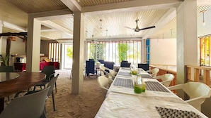A spacious room with a long table, chairs, and a ceiling fan. - WhiteSand (Himandhoo)