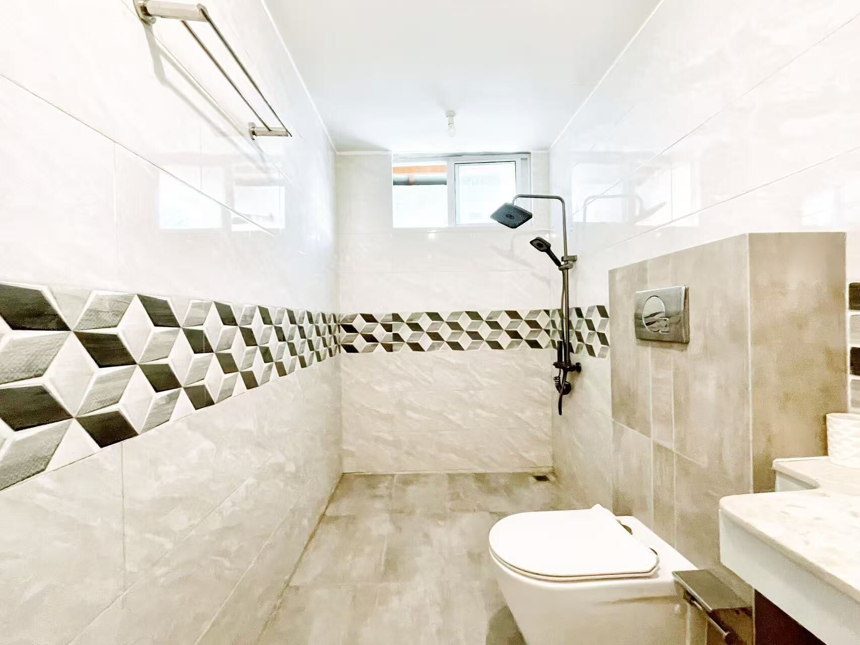 A modern bathroom with a shower, toilet, and a window.