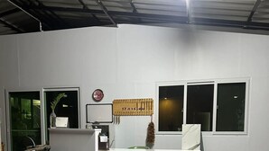 A reception desk with a clock, a calendar, and a vase of flowers. - 17 Garden  (Pattaya)