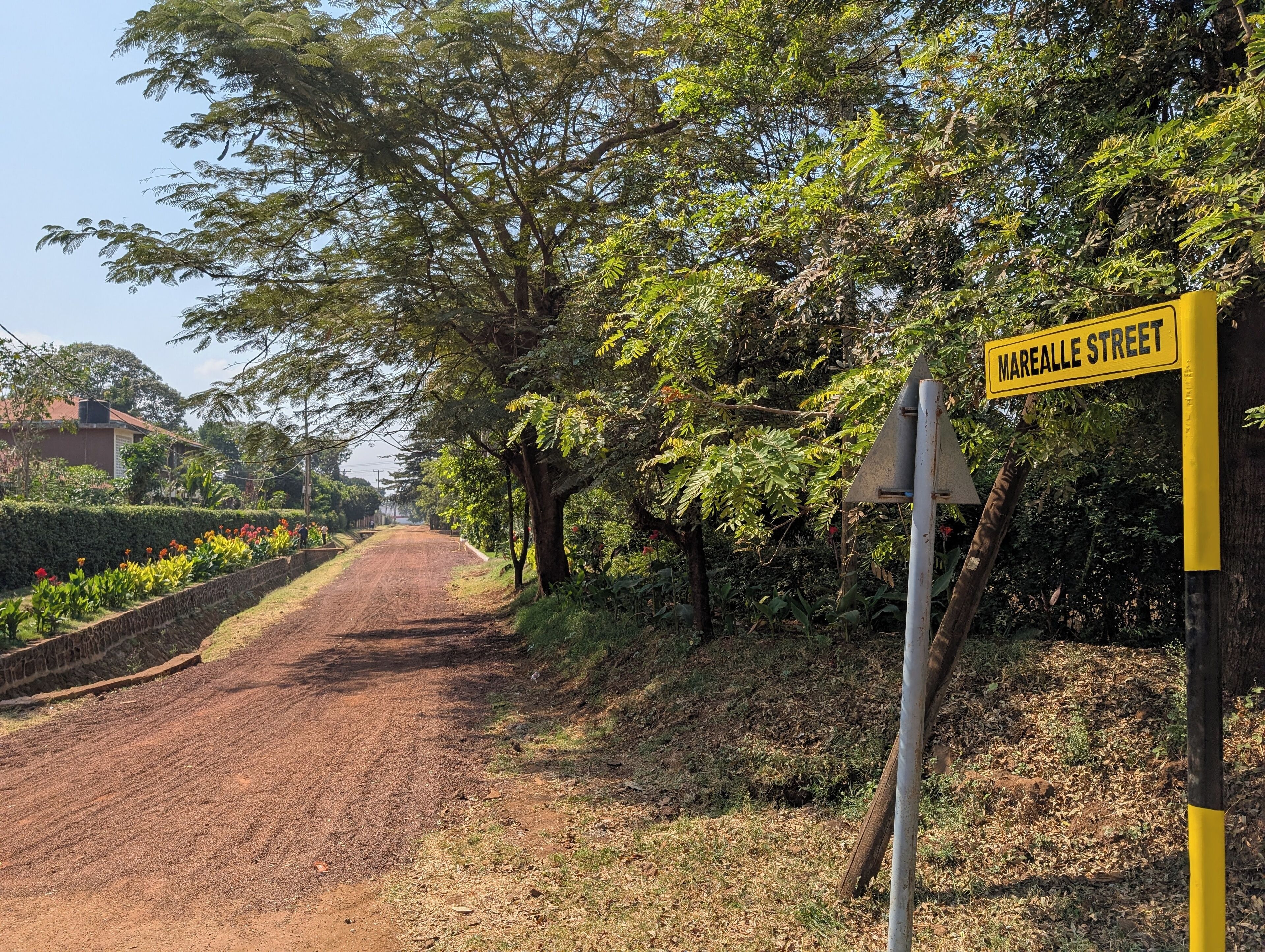 A dirt road with a yellow street sign reading "Marealle Street" and a metal traffic sign.
