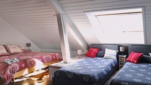 Ein Schlafzimmer mit zwei Betten, einem Oberlicht und einem Fenster.