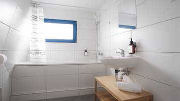 A modern bathroom with a bathtub, a sink, and a wooden vanity.