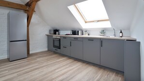 Eine moderne Küche mit Oberlicht, eingebauten Geräten und Holzbalken.