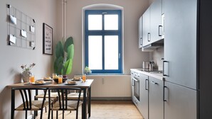 Eine moderne Küche mit Essbereich, ausgestattet mit einem großen Fenster, einer Heizung und einer Kücheninsel mit Stühlen.