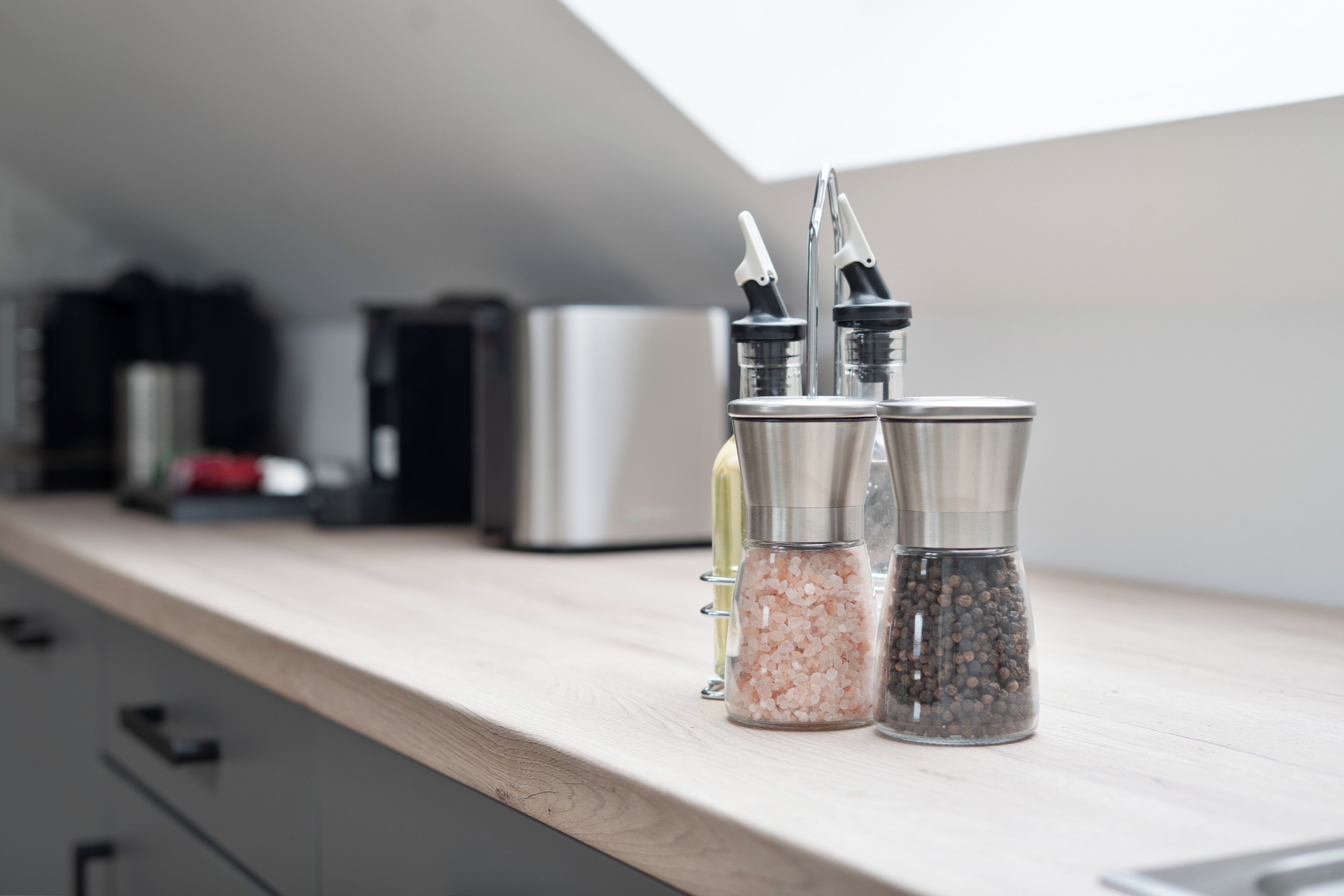 A kitchen counter with salt and pepper shakers, a coffee maker, and a toaster.