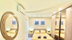 A modern bedroom with a large bed, bedside tables, a mirror, and a wardrobe. - Santa Venera - The Papillon Penthouse (L-Imsida)