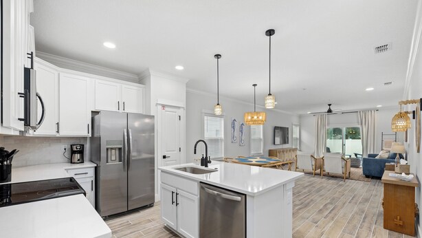 A modern kitchen with white cabinets, stainless steel appliances, and a central island.