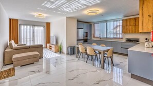 Un appartement moderne comprenant un salon, un coin repas, une cuisine et un balcon.