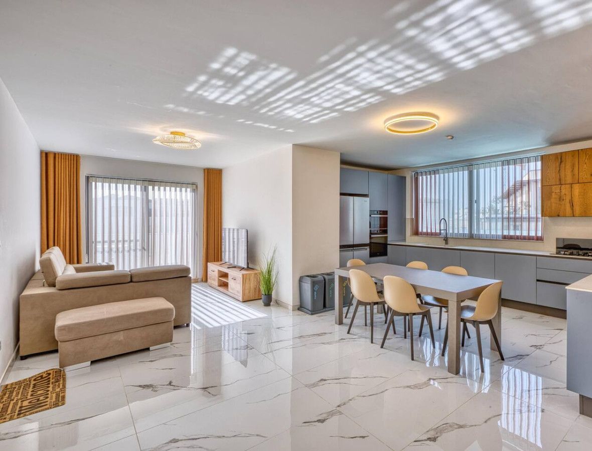 A modern apartment with a living room, dining area, kitchen, and a balcony.