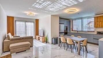 A modern apartment with a living room, dining area, kitchen, and a balcony.