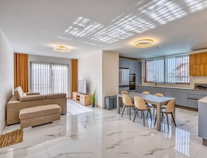 Un apartamento moderno con sala de estar, comedor, cocina y un balcón.