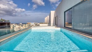 Une piscine à débordement située sur le toit, offrant une vue dégagée sur les gratte-ciel de la ville.
