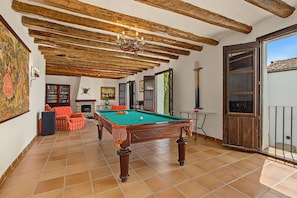 A spacious room with a pool table, a fireplace, and a balcony with a view. - Country House 'Medina' with Private Pool, Private Terrace and Wi-Fi (Agón)
