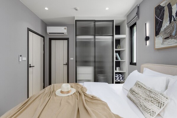 Une chambre à coucher avec un lit, une armoire, un placard et un tableau au mur.