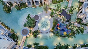 A rooftop pool area with multiple water features, including a central fountain, a circular water feature, and a children's play area. - The Title Legendary BangTao by TropicLook (Choeng Thale)