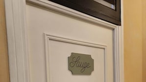 A white door with a sign that reads "Sauge" and a door handle. - Gîte Maison Chiche (Bain-de-Bretagne)