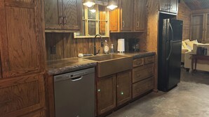 A kitchen with wooden cabinets, a black refrigerator, a dishwasher, and a sink with a faucet. - 
Dularge Fishing Hideaway!
Family and Pet friendly (Houma)