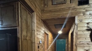 A narrow wooden hallway with a refrigerator on the left, a light fixture above, and a teal door at the end. - 
Dularge Fishing Hideaway!
Family and Pet friendly (Houma)