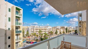 Varanda com vista para a cidade, uma mesa e uma cadeira.