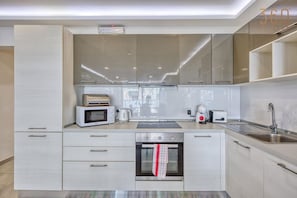 A modern kitchen with a built-in oven, microwave, and toaster.