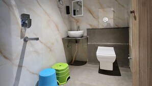 A modern bathroom with a marble floor, a white sink, a toilet, a shower, and a mirror. - Lakhdatar Hotel (Deoghar)