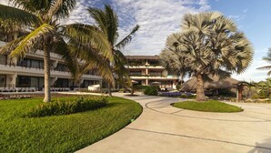 Un resort con un vialetto curvo, palme e un edificio con balconi.